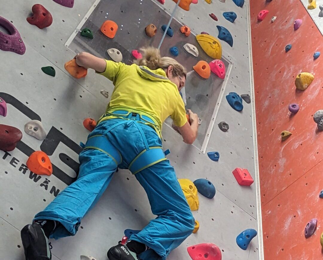 Frau klettert an einer Kletterwand im [cityrock] Stuttgart